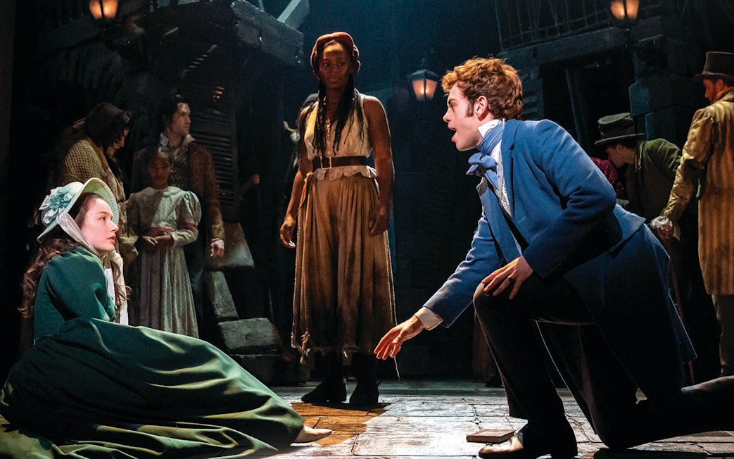 Actors performing a scene from Les Miserables on stage.