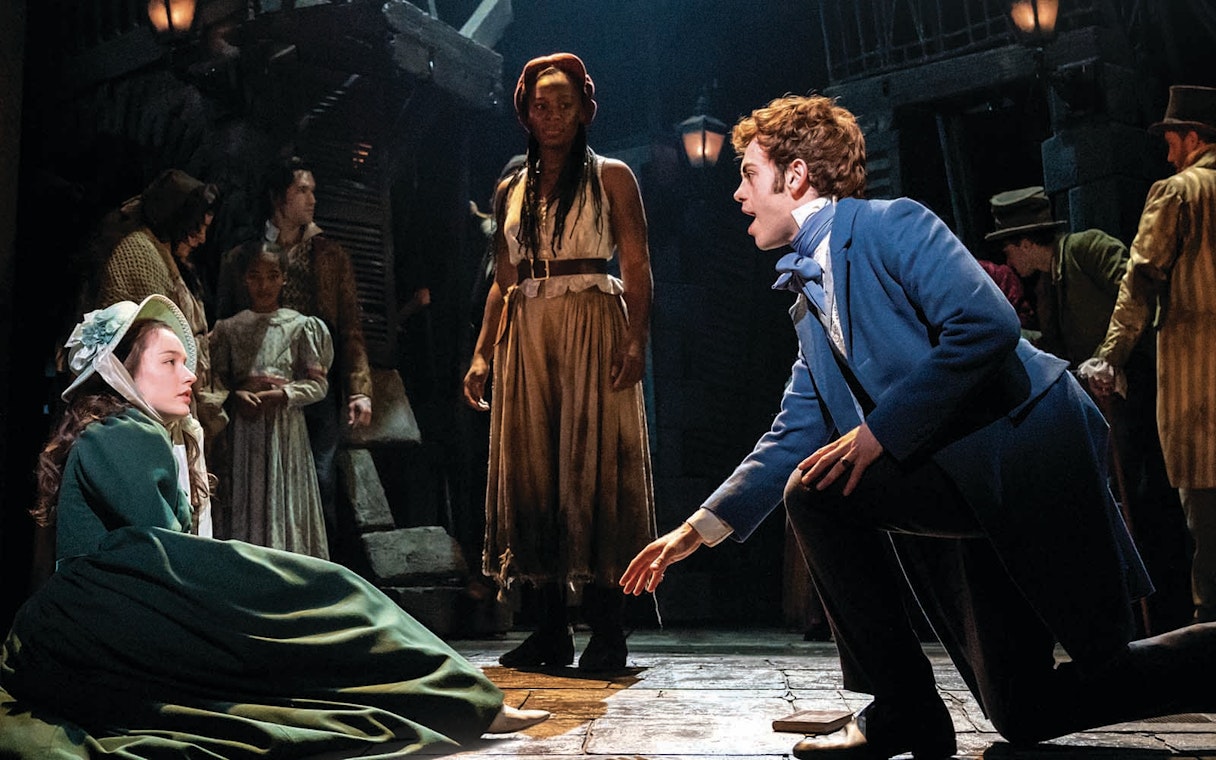 Actors performing a scene from Les Miserables on stage.