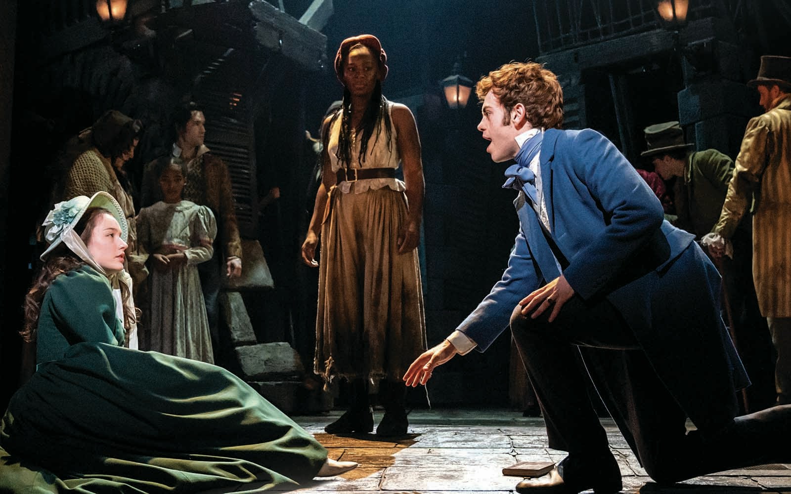 Actors performing a scene from Les Miserables on stage.