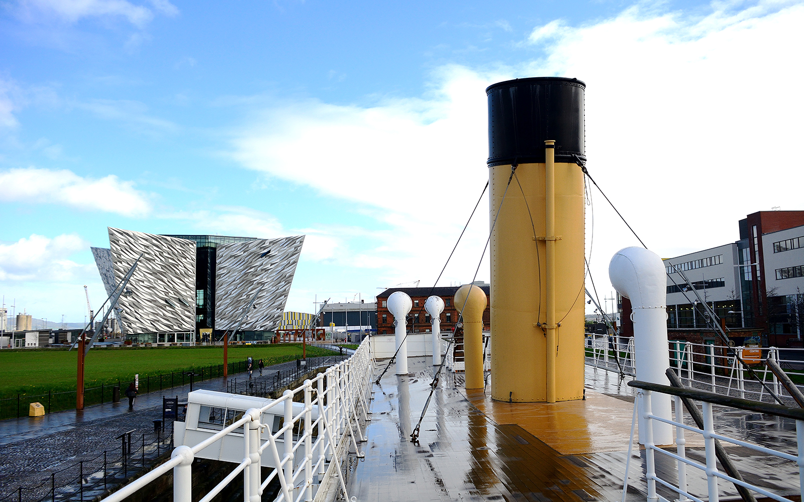 SS Nomadic docked in Belfast with hop-on hop-off tour bus nearby.