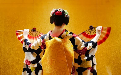 Geisha performing with fans in traditional attire, Kyoto.