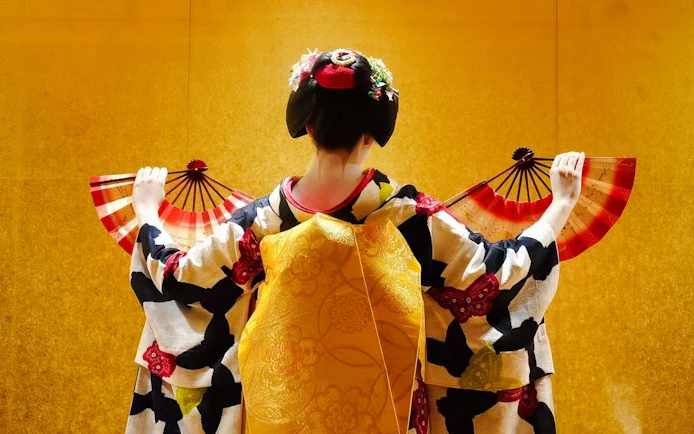 Geisha performing with fans in traditional attire, Kyoto.