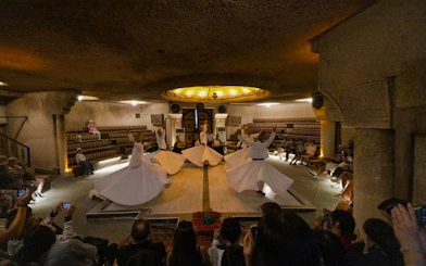 Whirling Dervishes performing Sema ceremony in a cave setting, Cappadocia.