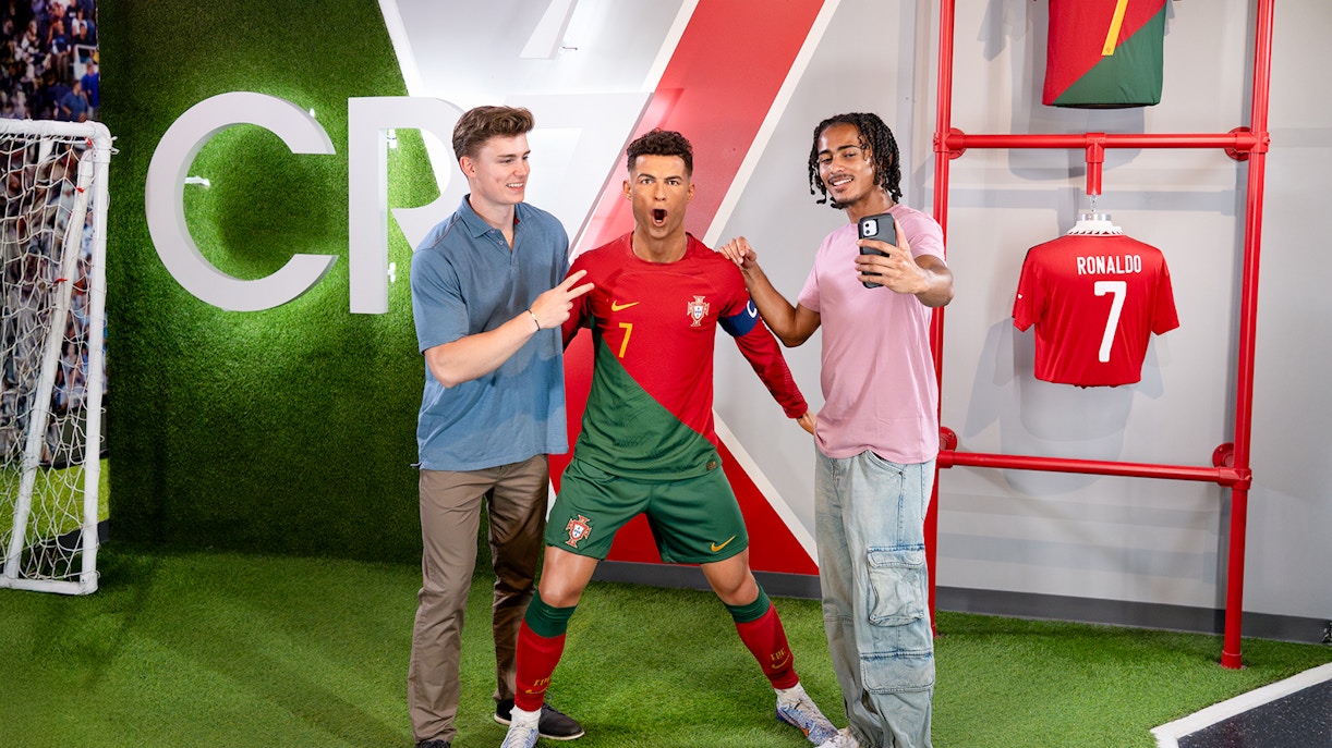 Two men taking a selfie with Ronaldo's wax figure at Madame Tussauds, New York.