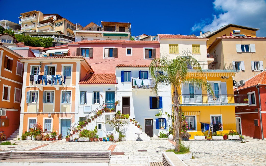 Colorful houses in Parga city, Corfu, with laundry hanging and potted plants.