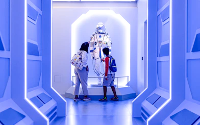 Visitors observing a space exhibit at Louvre Abu Dhabi.