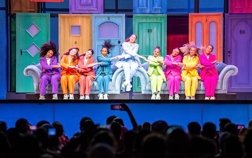 Performers in colorful suits dancing on stage at Global Village Dubai.