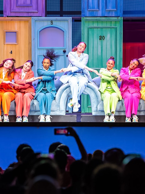 Performers in colorful suits dancing on stage at Global Village Dubai.