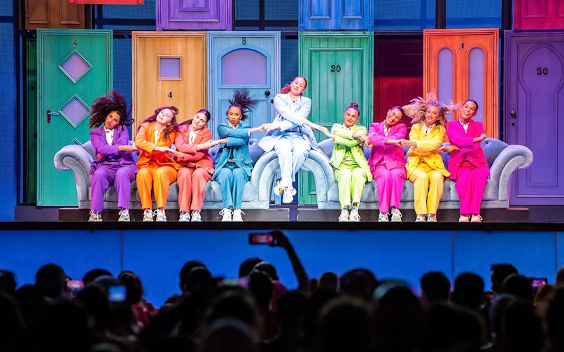 Performers in colorful suits dancing on stage at Global Village Dubai.