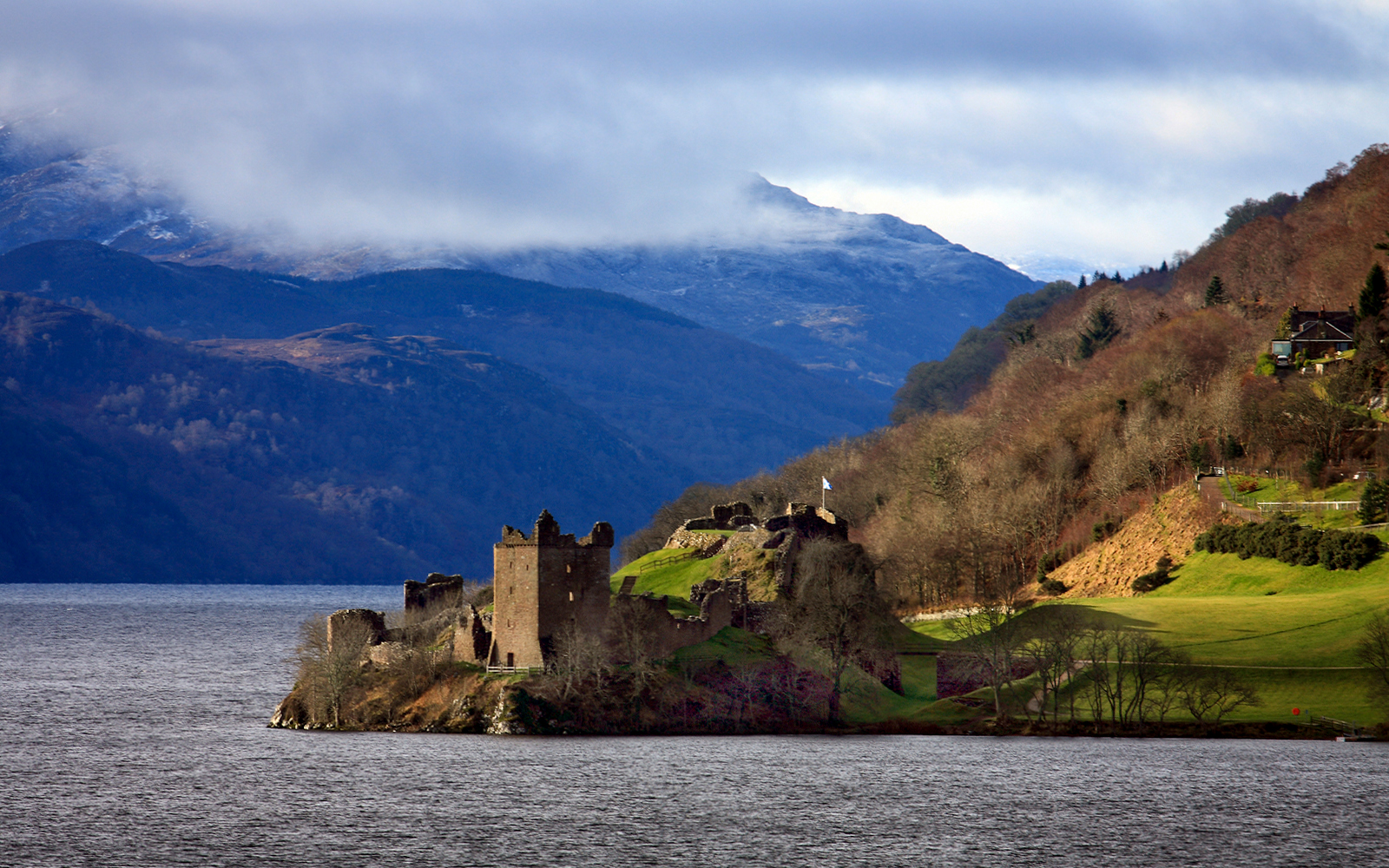 Castle Urquhart overlooking Loch Ness with scenic Highlands backdrop in Inverness, Scotland.