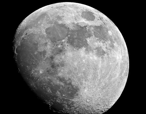 Moon in waxing gibbous phase with visible craters and surface details.