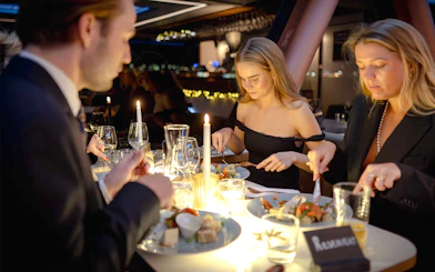 Guests dining by candlelight on an Oslo dinner cruise.