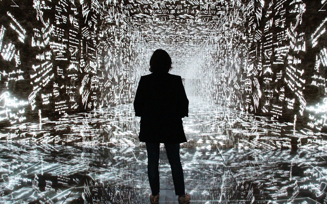 Visitor exploring digital art installation at Casa Batlló, Barcelona.