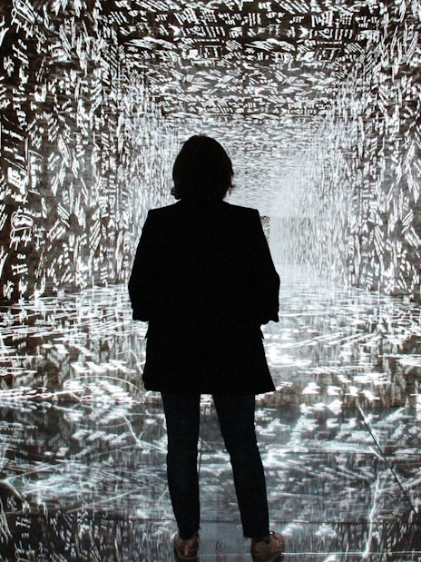 Visitor exploring digital art installation at Casa Batlló, Barcelona.