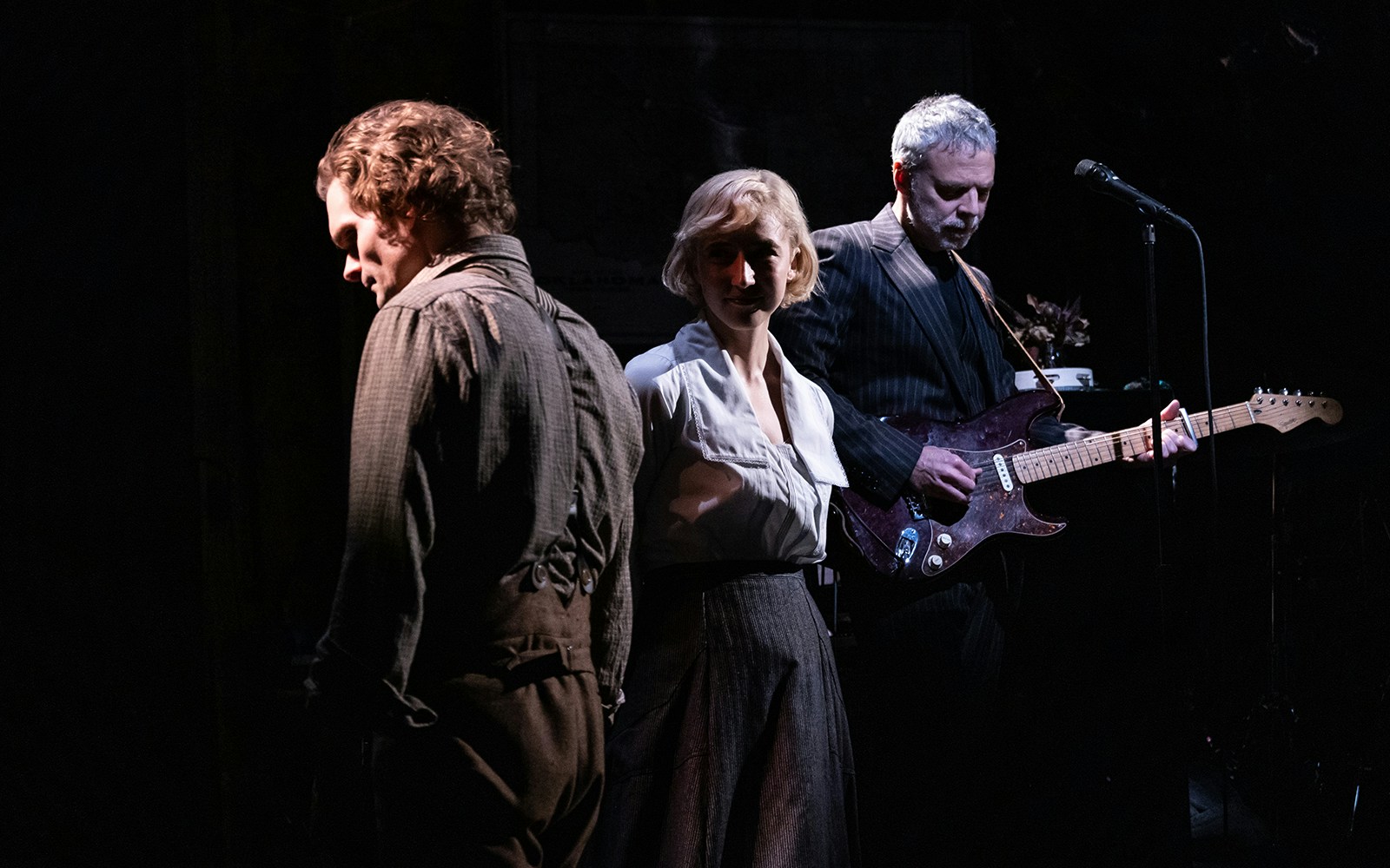 Musicians and actors performing on stage in a scene from "Dead Outlaw.