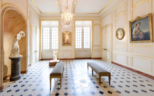 Interior of Cognacq Museum with sculptures and paintings in an elegant gallery.