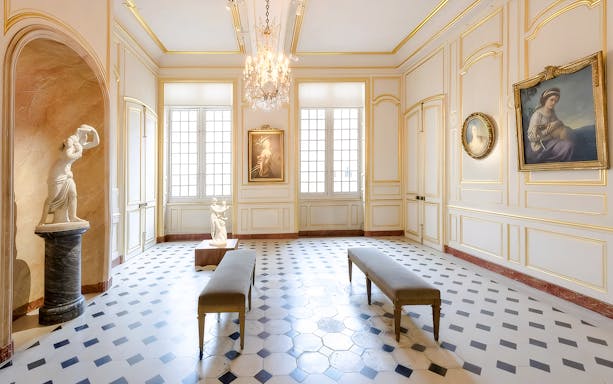 Interior of Cognacq Museum with sculptures and paintings in an elegant gallery.