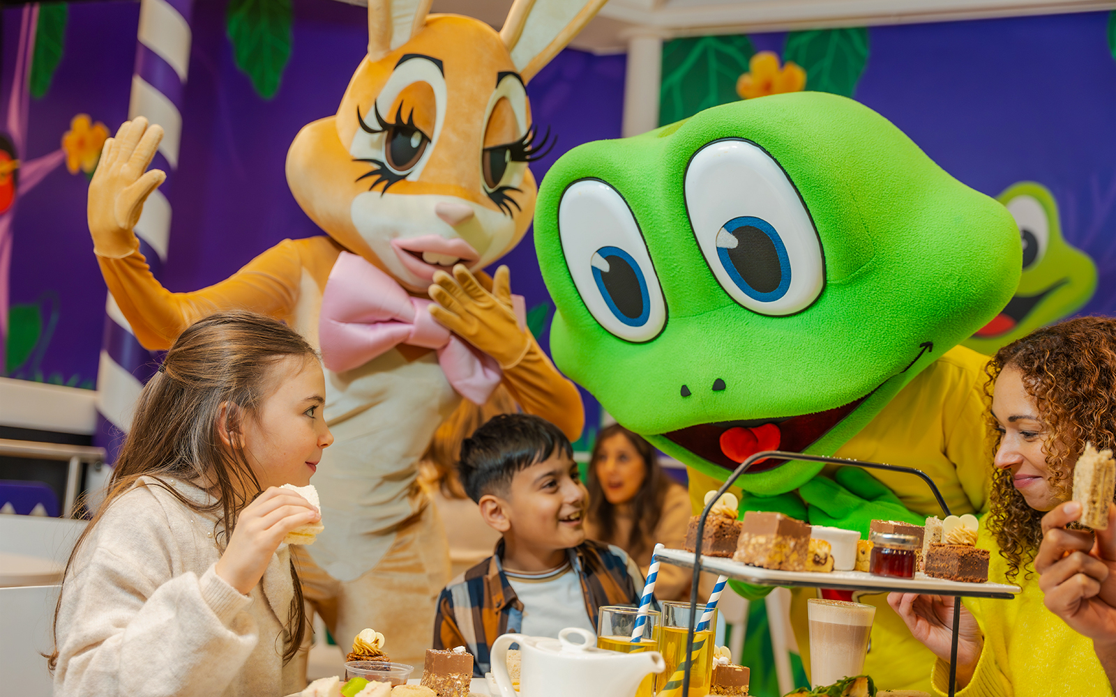 Children enjoying afternoon tea with character mascots at Cadbury World.