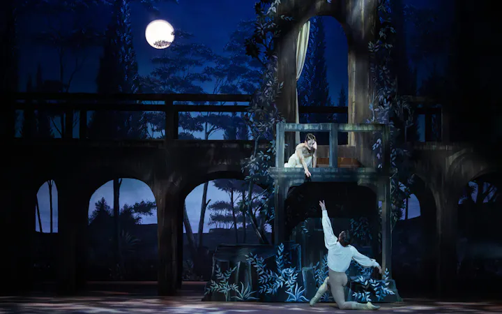Australian Ballet's Romeo and Juliet balcony scene performance under moonlight.