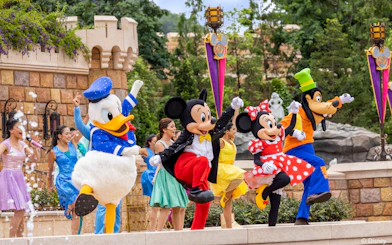Disney characters performing at Disneyland Hong Kong with castle backdrop.