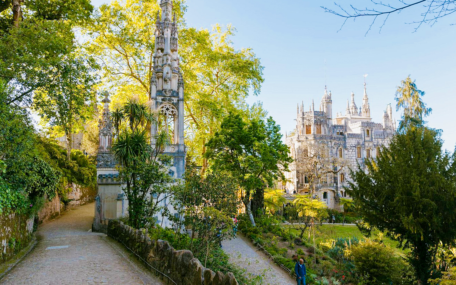 Quinta da Regaleira garden path with ornate tower and palace in Sintra, Portugal.