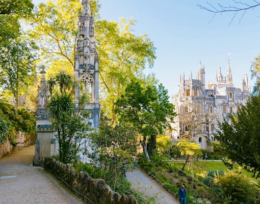 Quinta da Regaleira's ornate facade with lush gardens in Sintra, Portugal.