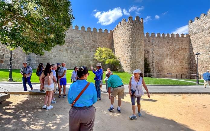 Tourists admiring the medieval city walls of Ávila, Spain.