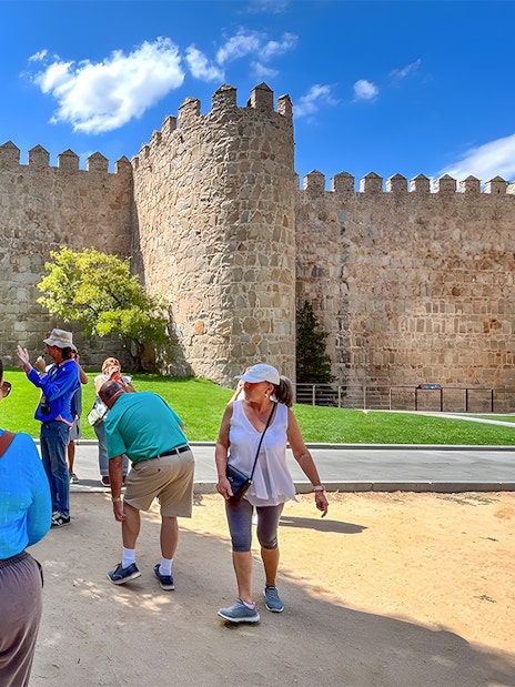 Tourists admiring the medieval city walls of Ávila, Spain.