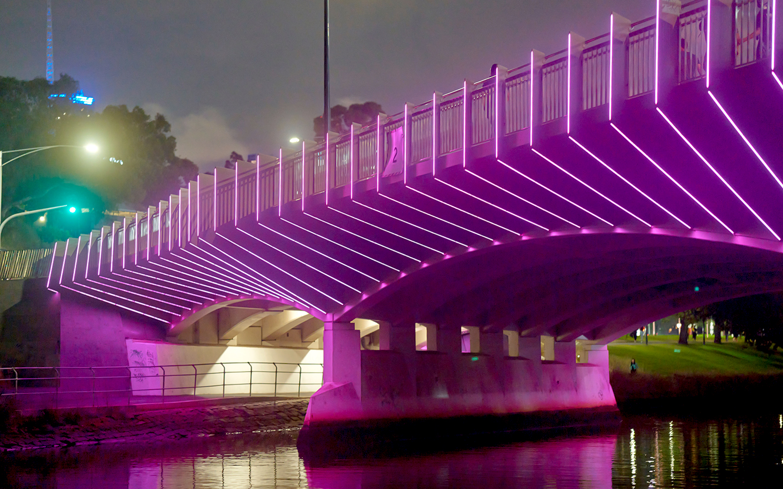 Melbourne bridge illuminated in pink lights during the Spirit of Melbourne Dinner Cruise.