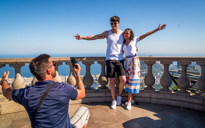 Guide photographing tourists at Christ the Redeemer, Rio de Janeiro.