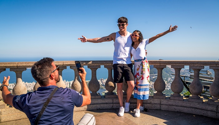 Guide photographing tourists at Christ the Redeemer, Rio de Janeiro.