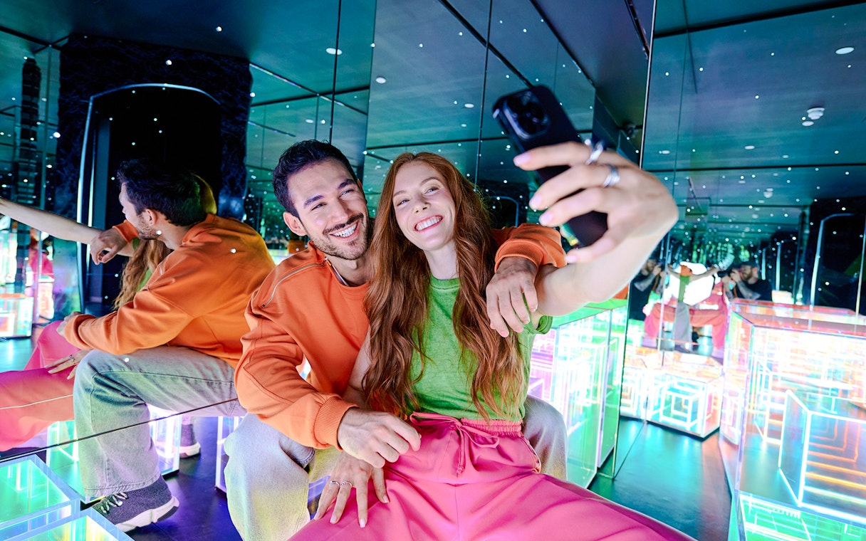 Guests taking a selfie in the mirrored room at Paradox Museum London.