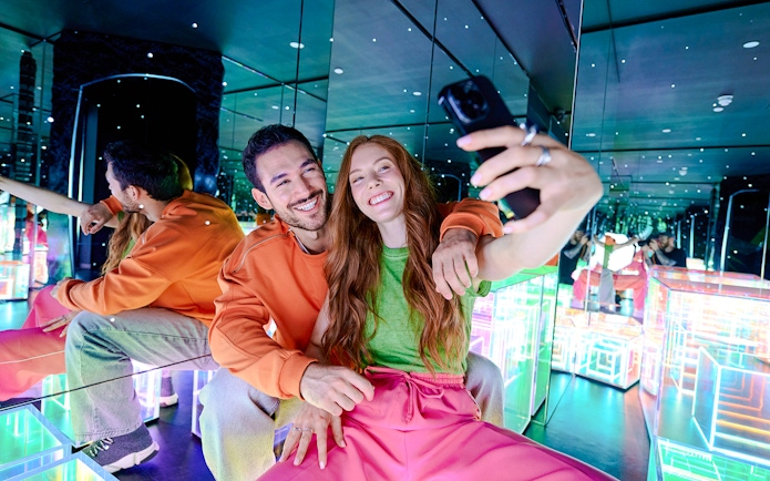 Guests taking a selfie in the mirrored room at Paradox Museum London.