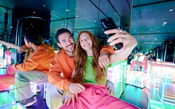 Guests taking a selfie in the mirrored room at Paradox Museum London.