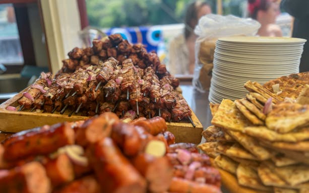 Skewers and sausages with flatbread served on a boat.