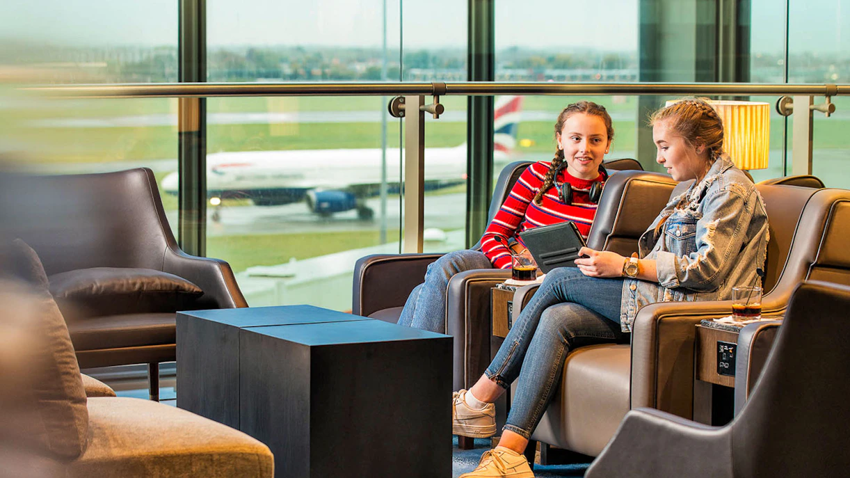 Heathrow Plaza Premium Lounge with travelers relaxing and viewing the runway.