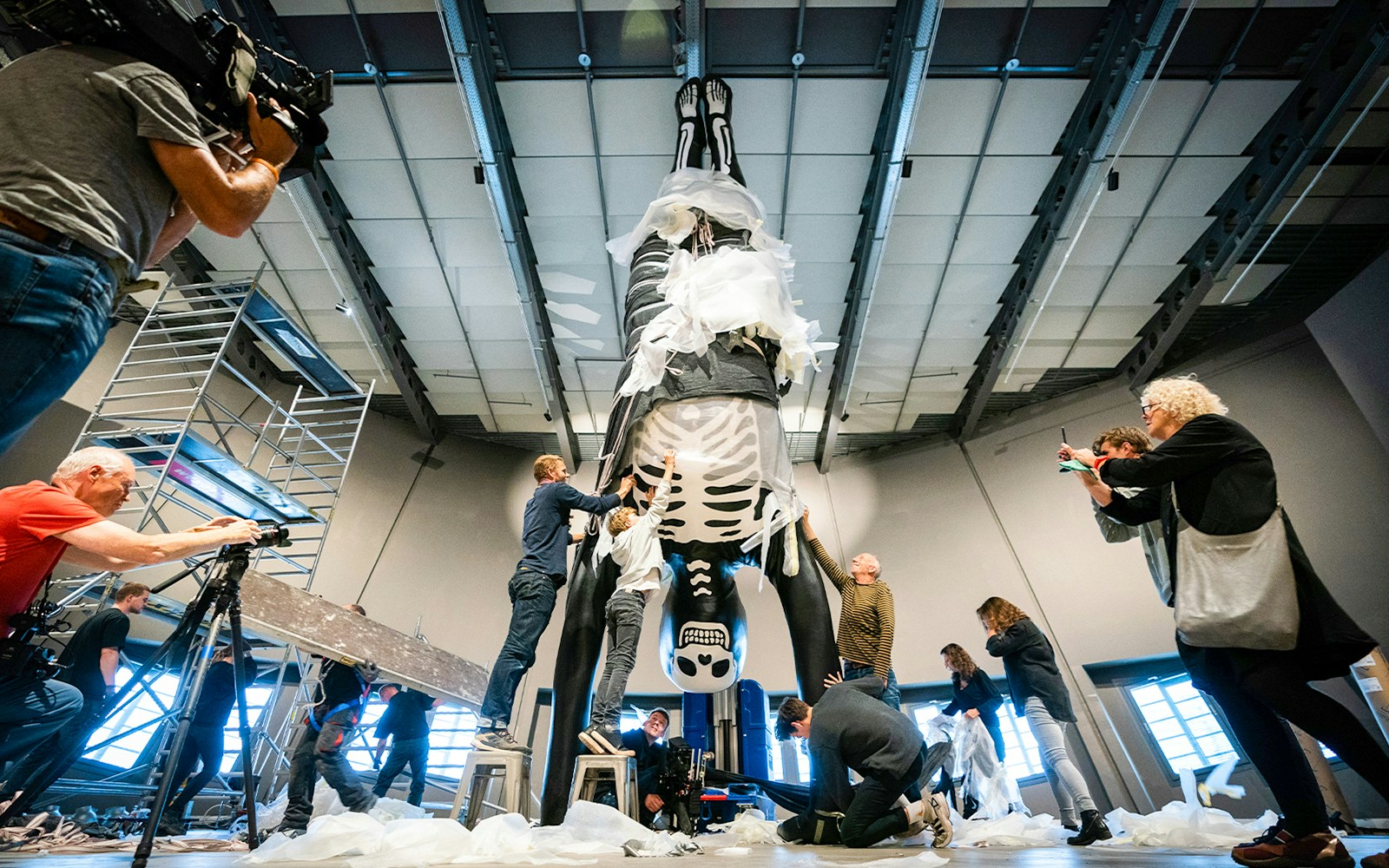 People preparing a large skeleton exhibit at NEMO Science Museum.
