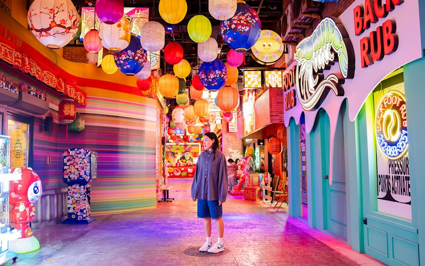 Tourist exploring vibrant lantern-lit street in House of Hype, Dubai.