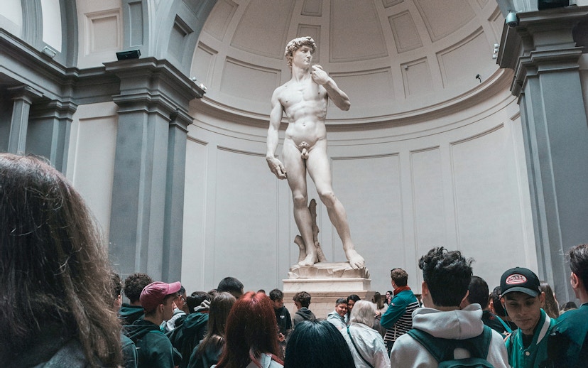 Visitors viewing Michelangelo's David statue in Florence, Italy.