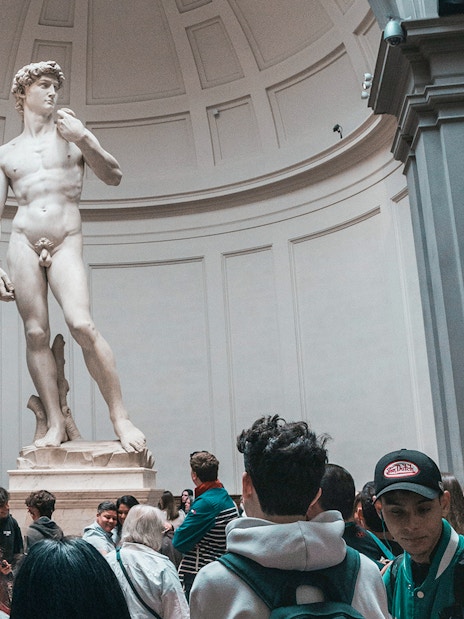 Visitors viewing Michelangelo's David statue in Florence, Italy.