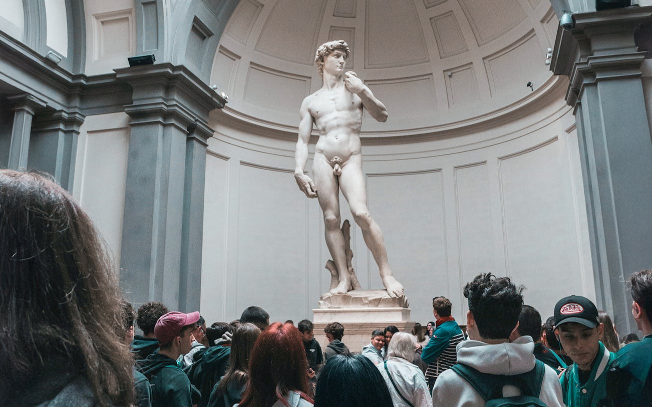 Visitors viewing Michelangelo's David statue in Florence, Italy.