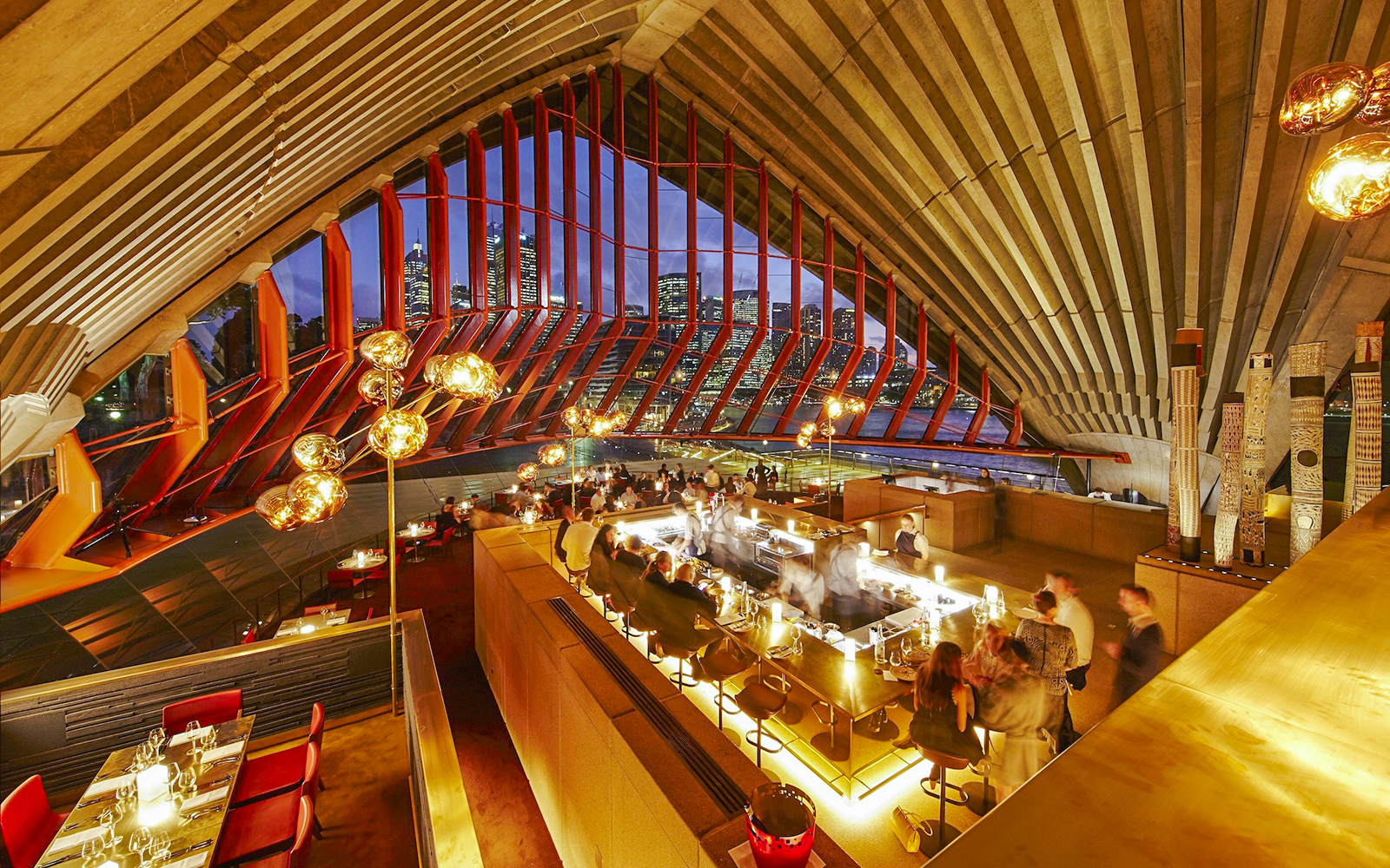 Bennelong restaurant interior at Sydney Opera House with city skyline view.