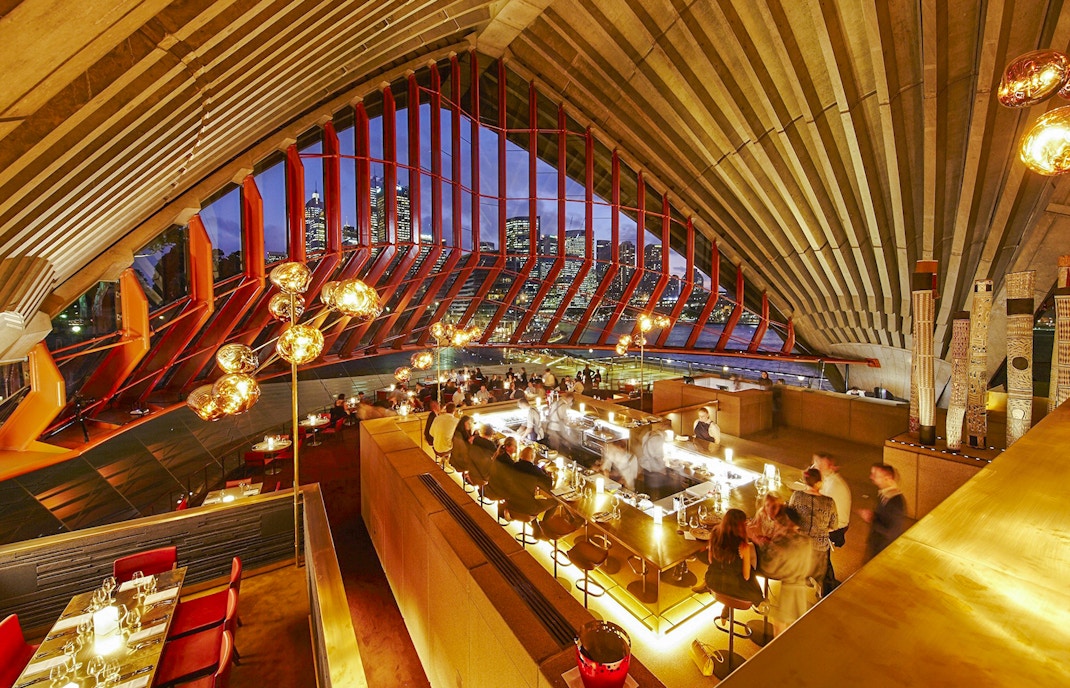Bennelong restaurant interior at Sydney Opera House with city skyline view.
