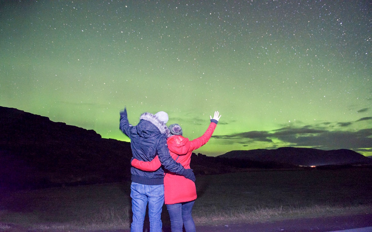 Guests viewing Northern Lights on a sightseeing bus tour.