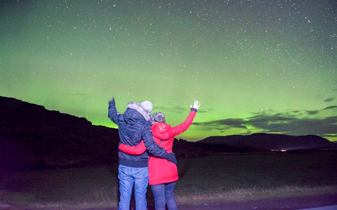 Guests viewing Northern Lights on a sightseeing bus tour.