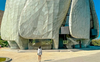 Baháʼí House of Worship in Santiago, Chile, with a visitor approaching the unique architectural facade.