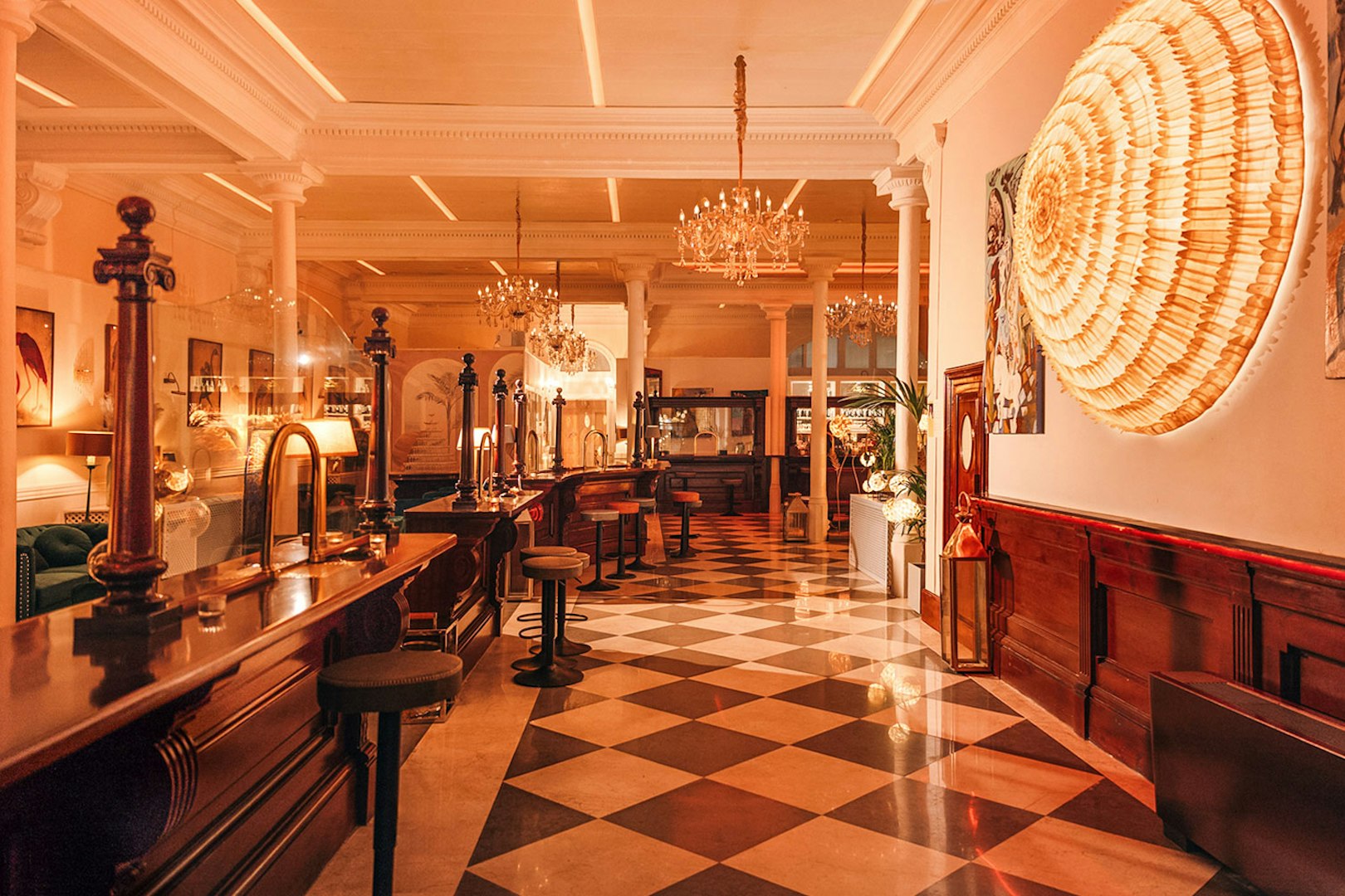 Elegant interior of a bar with chandeliers and checkered floor in Laietana, Barcelona.
