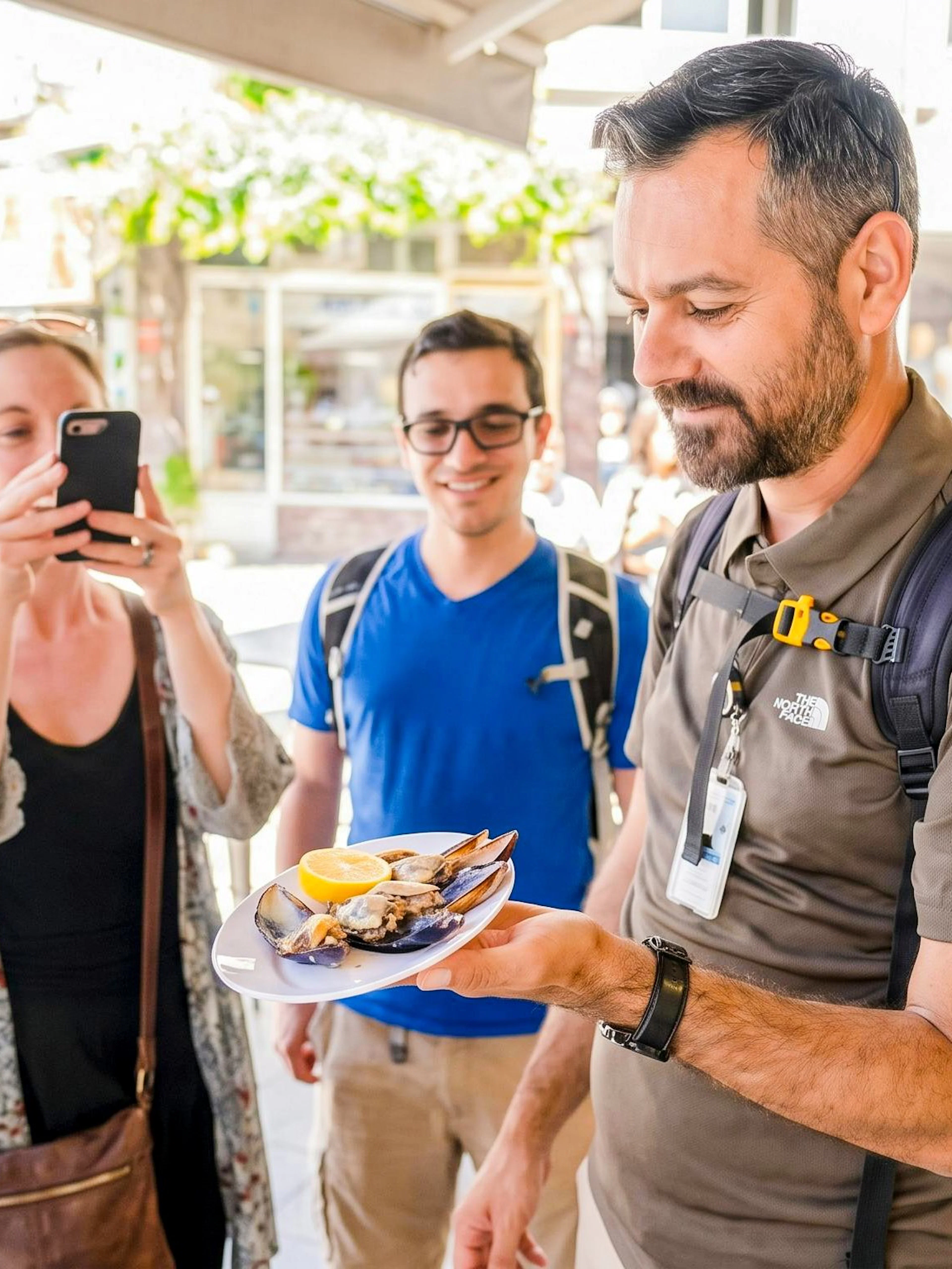 Man holding a plate of mussels with lemon during Istanbul food tour.