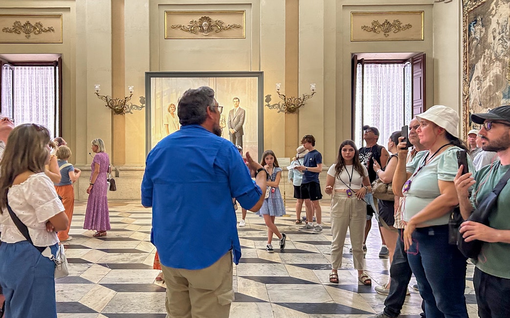 Tour group inside the Royal Palace of Madrid during a guided visit.