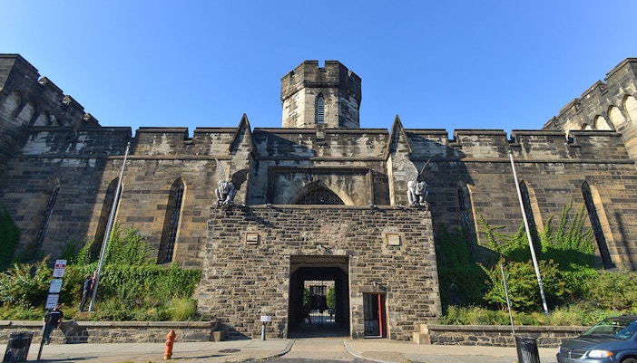 Eastern State Penitentiary entrance with stone gargoyles and historic architecture.